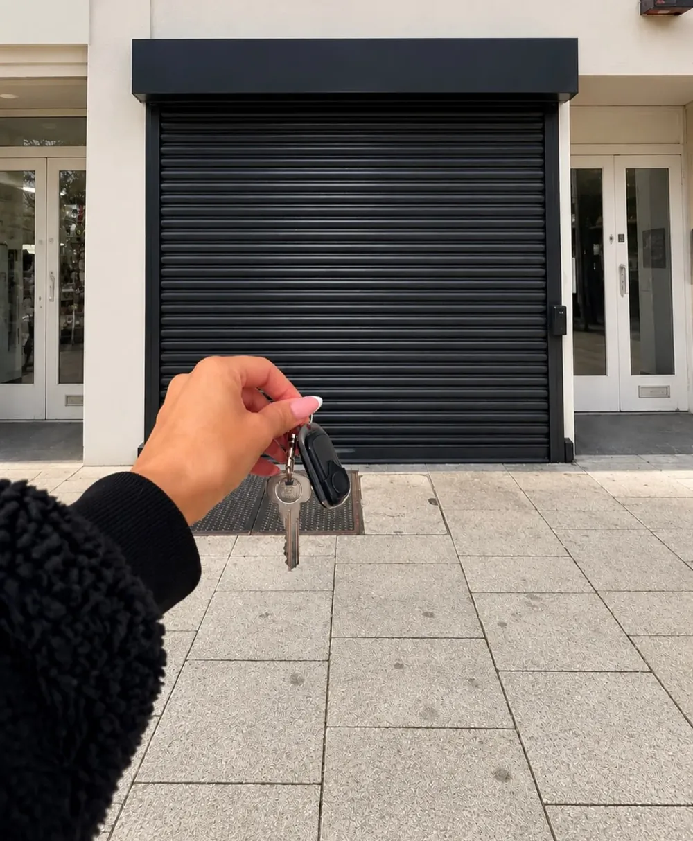 Rebecca holding up the keys outside her new shopfront in St Helens